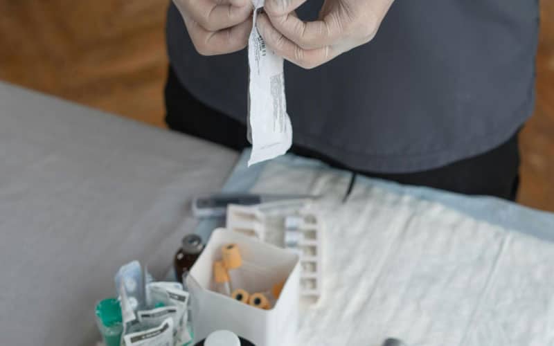 infirmiere préparant un pansement infirmiers avec des pansements et des desinfectants devant elle