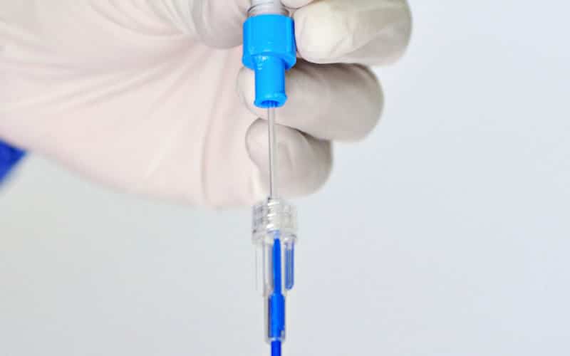 zoom sur une aiguille de perfusion manipulée par une infirmière